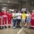 Gruppenfoto aller Sanitäter:innen und Patient:innen in der Rotkreuz-Garage.