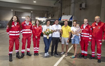 Gruppenfoto aller Sanitäter:innen und Patient:innen in der Rotkreuz-Garage.