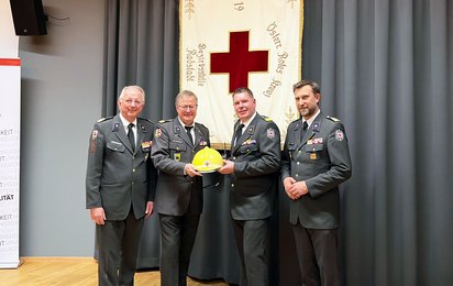 Gruppenaufnahme von links mit Werner Aufmesser, Gerhard Wechselberger, Markus Moser und Stefan Herbst. Wechselberger und Moser halten einen Rotkreuzhelm und ein Funkgerät.