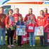 Gruppenfoto der Familie und Rotkreuz-Mitarbeitenden bei der Geschenkübergabe vor dem Rettungsauto