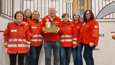 Sepp Osanger in der mitte mit 6 Damen, die ihm zum Geburstag gratulieren - auf einer Stiege stehend mit RK-Gewand