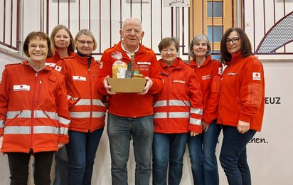 Sepp Osanger in der mitte mit 6 Damen, die ihm zum Geburstag gratulieren - auf einer Stiege stehend mit RK-Gewand