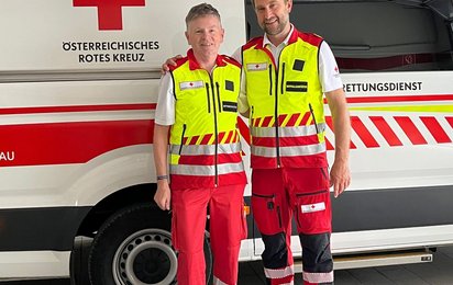 Zwei Rettungssanitäter stehen vor einem Rettungswagen, links Hubert Leitinger, recht Stefan Herbst