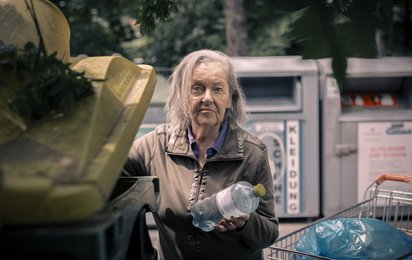Eine Dame sammelt Pfandflaschen