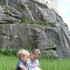 Zwei Kinder sitzen in der Wiese vor der Kinderburg Rappottenstein und lesen ein Buch.