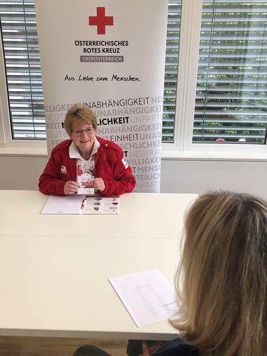 Gesundheits- und Sozialbegleiterin Ingrid Pechmann sitzt am Tisch gegenüber ihrer Klientin