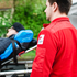 Sanitäter im Vordergrund, Patient auf Trage im Hintergrund