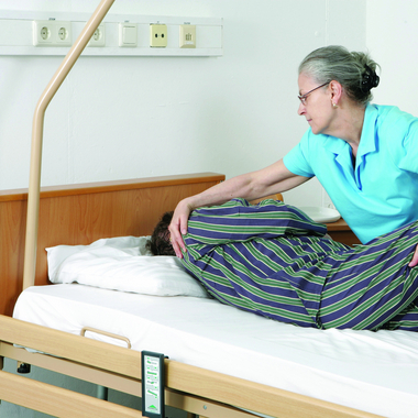 Pflegende Angehörige - © Österreichisches Rotes Kreuz Anna Stöcher Pflege daheim kann für betreuende Angehörige leichter gemacht werden. Im Bild eine pflegende Angehörige, die einen pflegebedürftigen Mann umlagert