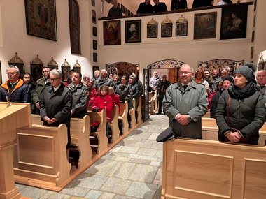 Eine Gruppe von Personen während einer Messe in einer kleinen Kirche