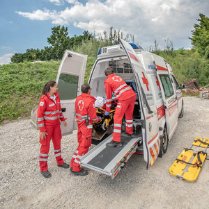 Drei Sanitäter sind am Notfallort eingetroffen und haben die verletzte Person in den Rettungswagen gebracht.