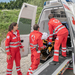 Drei Sanitäter sind am Notfallort eingetroffen und haben die verletzte Person in den Rettungswagen gebracht.