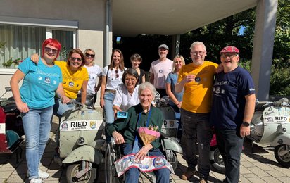 Gruppenfoto von Rosa mit Mitgliedern des Classic Vespa Club Ried im Innkreis und einer alten Vespa