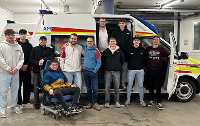 10 Zivildiener und 1 FSJ´ler stehen in der Garage vor einem Rettungswagen, gemeinsam mit vertreten der Bezirksstelle und dem Zivildienstsachbearbeiter Daniel Höller