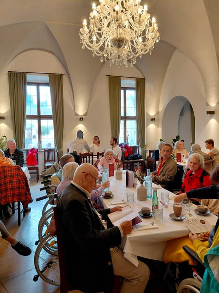 Bewohner:innen und Mitarbeiter:innen vom Seniorenwohnhaus Hallwang am Tisch bei Kaffee und Kuchen