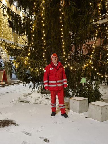 Sanitäter Severin Fuchs-Schickmaier vor beleuchtetem Weihnachtsbaum