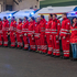 Rotkreuzsanitäter stehen in eine Reihe vor Rettungswägen