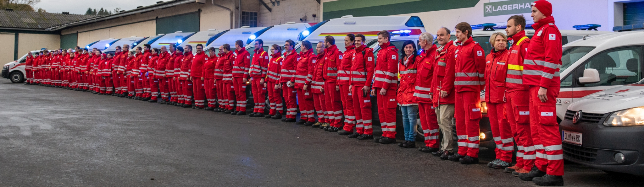Rotkreuzsanitäter stehen in eine Reihe vor Rettungswägen