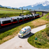 ein von einer Drohe fotografiertes Rettungsfahrzeug fährt neben einem Zug der ÖBB