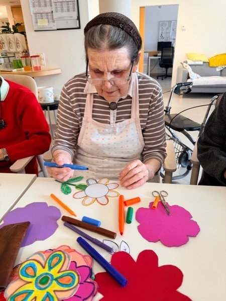 Bewohnerinnen des Seniorenwohnhauses helfen bei der Gestaltung der Wände mit.