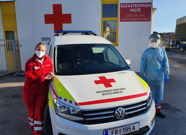 2 Mitarbeiter:innen des Covid-Teams vor dem Covid-HÄND-Fahrzeug