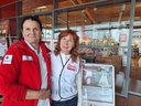 TÖT Aktionstag 2026 - © Österreichisches Rotes Kreuz / LV Niederösterreich Zwei Personen in Team Österreich Tafel-Kleidung und ÖRK-Kleidung stehen vor einem Supermarkteingang mit einem Informationsplakat zur Tafel-Aktion am 12.06.2026