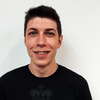 Portrait eines Mannes in schwarzem T-Shirt und kurzen, dunklen Haaren.
