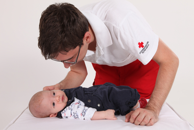 Baby wird von Rettungssanitäter erstversorgt