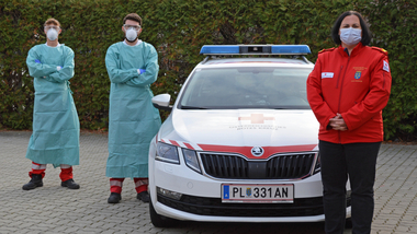 Bezirksstellenkommandantin Katrin Wiesinger mit zwei Rotkreuz-Sanitätern, die bei den Testungen helfen werden: Alexander Budik und Moritz Pasteiner in Schutzausrüstung, die für die Testungen getragen wird, um selbst nicht infiziert zu werden.