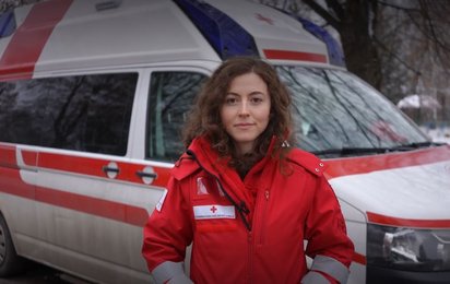 Camilla Mittelberger vom Roten Kreuz vor einem Rotkreuz Auto