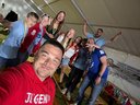 Jugendliche und Betreuer stehen auf Heurigenbänken und lächeln in ein Selfie