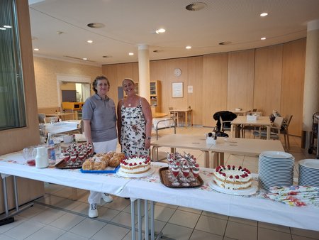 Zwei Frauen stehen hinter den Tischen, auf denen das Buffet angerichtet wurde