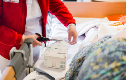 Pflegerin versorgt Patientin im Bett