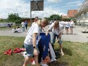 Kinder versuchen Löcher in einem Fass mit Tüchern zu stopfen