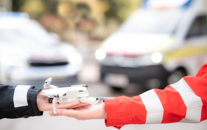 Drohne wird von einer Polizistin und einem Rettungssanitäter gehalten