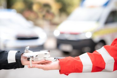 Drohne wird von einer Polizistin und einem Rettungssanitäter gehalten