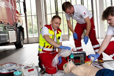 Rotkreuz-Sanitäter üben an einer Puppe eine Wiederbelebung