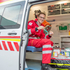 Marian Cernko - Notfallsanitäter - sitzt in einem Rettungswagen und zieht gerade ein Medikament aus einer Ampulle mit einer Spritze auf.