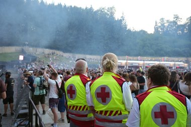 Drei Rotkreuz-Sanitäter:innen beobachten das ELF-Publikum