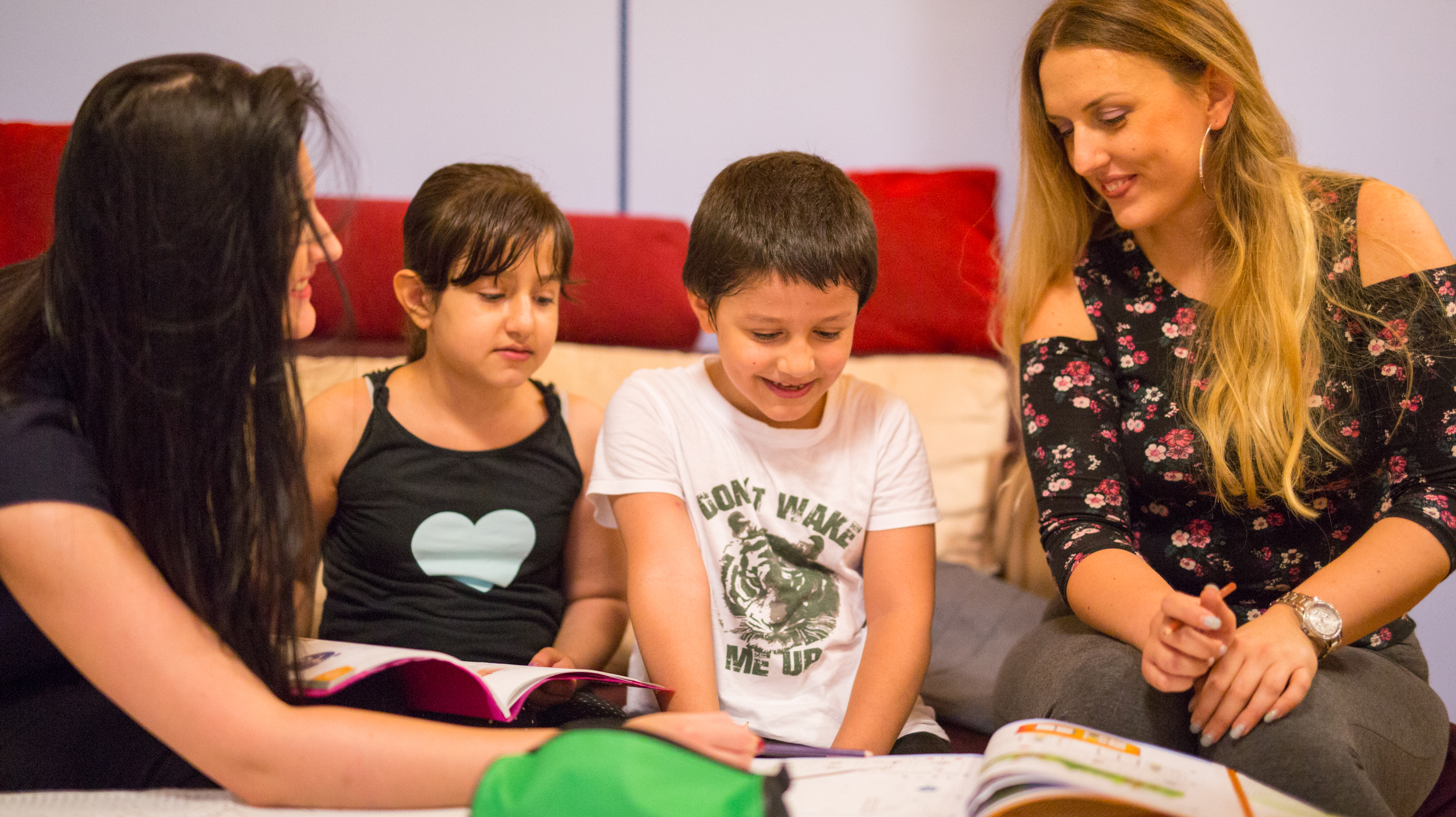 © ÖRK/Kellner Holly Thomas Zwei Rotkreuz-Freiwillige helfen Kindern beim Lernen