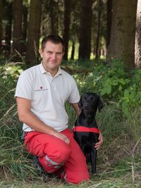 Andreas mit Aesculab - © Anna Zehetner Hundeführer Andreas mit schwarzen Labradorrüden Aescu