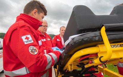 Ein Rotkreuz MA steht bei der Trage