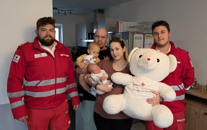 Gruppenfoto der Familie und RK-Mitarbeiter:innen