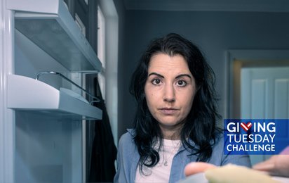 Frau schaut traurig in leeren Kühlschrank, Sticker zu Giving Tuesday