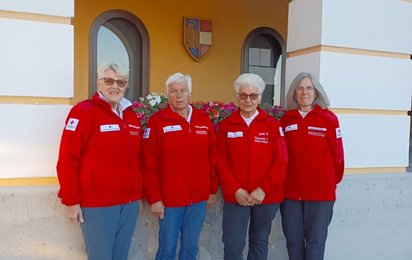 Seniorenbetreuerin stehen vor Gebäude in Rotkreuz-Uniform