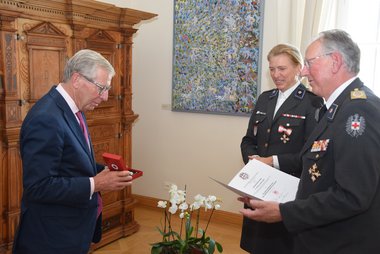 Präsident Dr. Werner Aufmesser und Landesgeschäftsführerin Sabine Tischler überreichen Landeshauptmann Dr. Wilfried Haslauer das Goldene Ehrenzeichen des Roten Kreuzes Salzburg.