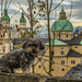 Auf Mauer sitzender Hund mit dem Salzburger Dom im Hintergrund