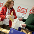 Auf dem Bild eine freiwillige die gerade Brot an einen Herren ausgiebt