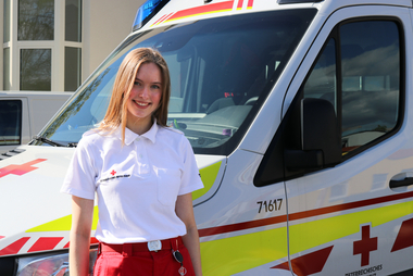 © Rotes Kreuz Graz-Stadt/ M. Stankic Felicia steht vor einem Rettungswagen.