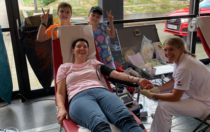 Typische Situation bei einer Blutspendeaktion des Roten Kreuzes, Frau auf Liege beim Blutspenden.