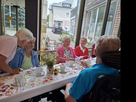 Die Bewohnerinnen des Jakobushauses an den gedeckten Tischen